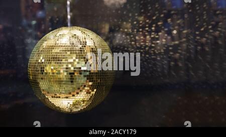 Golden mirror disco ball with bright golden rays, night party background photo with copy space. Stock Photo