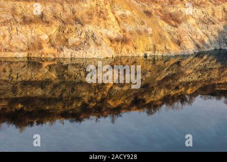 landscape of granite non-functioning quarry. Flooded with water. Against the background of clouds. Quarry mining Stock Photo