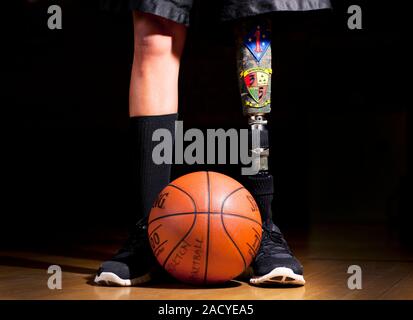 Amputee basketball athlete. The athlete is a US marine wounded in combat, and has a prosthetic leg. He is part of the Wounded Warrior Regiment's Warri Stock Photo