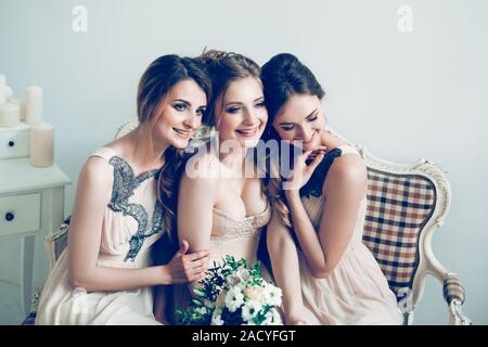 happy bride with her two friends sitting on the couch . Stock Photo