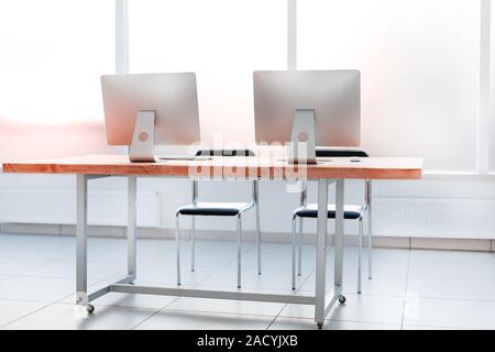 close up. workplace with computers on the table in an empty office. Stock Photo