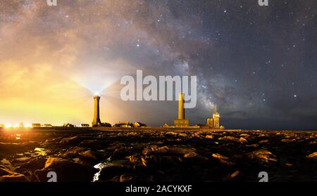 Night sky over a harbour. The Milky Way is seen arching from the Eckmuhl lighthouse. The brightest object to its right is Saturn. The cirrus clouds at Stock Photo