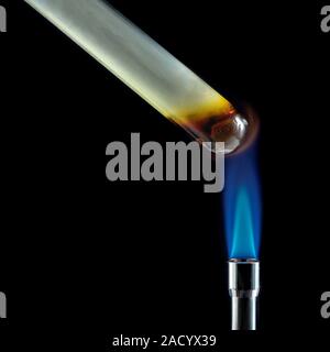 Sulphur being heated in a test tube. Sulphur is a yellow solid at room temperature mostly made of octaatomic ring-shaped molecules. When heated above Stock Photo