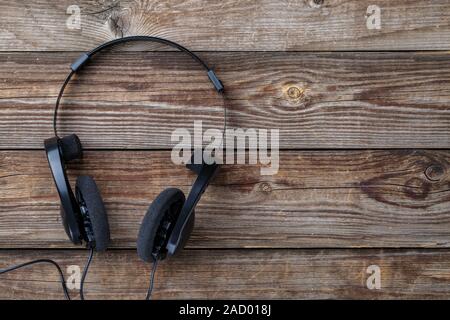 Headphones over wooden table. Stock Photo