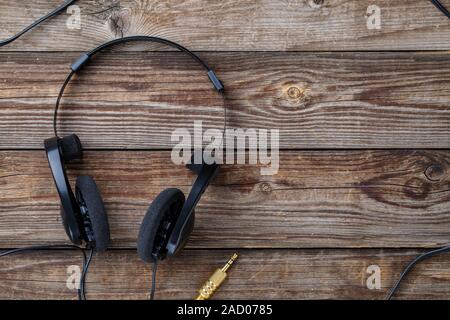 Headphones over wooden table. Stock Photo