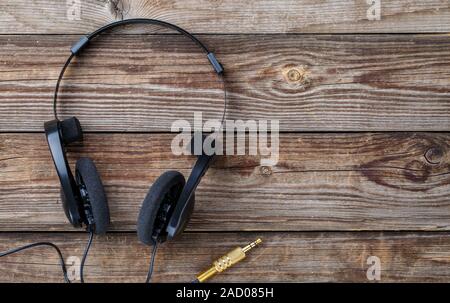 Headphones over wooden table. Stock Photo
