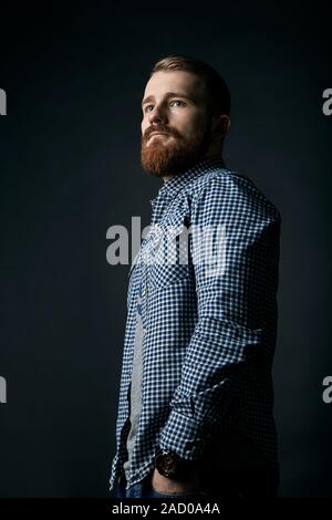 Pensive red bearded man studio portrait on dark background Stock Photo
