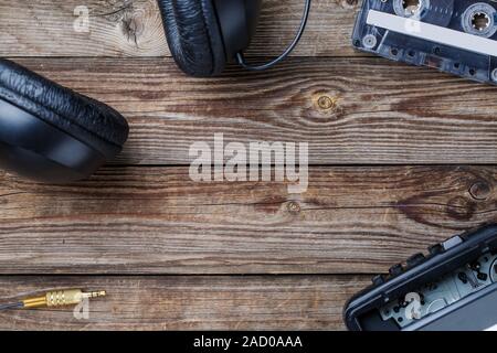 Cassette tapes, player and headphones over wooden table. top view. Stock Photo