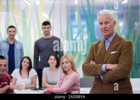 portrait of  teacher with students group in background Stock Photo