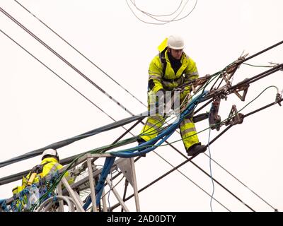 Technicians working to replace old insulators on a pylon in Barrow on Soar, Leicestershire, UK. Stock Photo