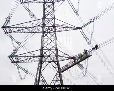 Technicians working to replace old insulators on a pylon in Barrow on Soar, Leicestershire, UK. Stock Photo