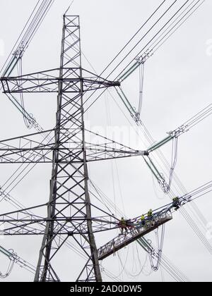 Technicians working to replace old insulators on a pylon in Barrow on Soar, Leicestershire, UK. Stock Photo