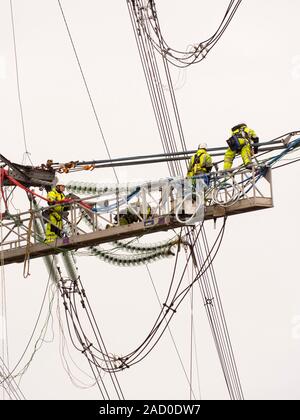 Technicians working to replace old insulators on a pylon in Barrow on Soar, Leicestershire, UK. Stock Photo