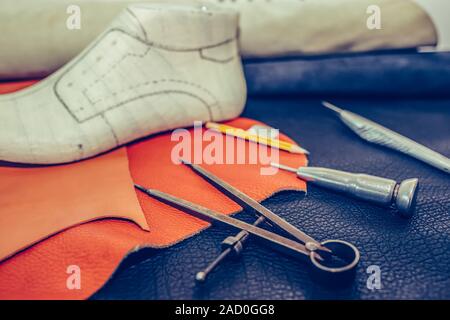 Shoemaker's work desk. Tools and leather at cobbler workplace. Shoes, leather, shoemaking tools and set of leather craft tools . Shoes maker tools on Stock Photo
