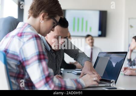 young Business couple working on laptop, businesspeople group on meeting in background Stock Photo