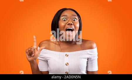 Excited African American Girl Pointing Finger Up, Orange Background, Panorama Stock Photo