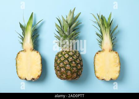 Pineapples on blue background, space for text. Juicy fruit Stock Photo
