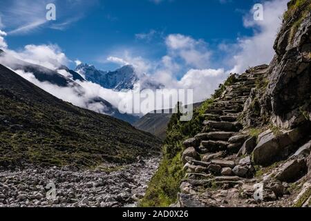 View of  Mt. Tamserku from Gokyo valley, trekking path leading up, monsoon clouds moving in Stock Photo