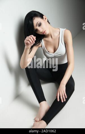 dark-haired model on floor in studio Stock Photo