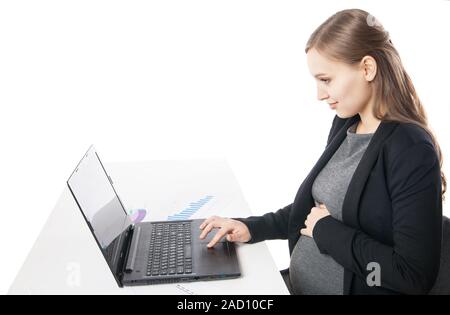 Side view of smiling pregnant woman at desktop working on laptop Stock Photo