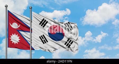 Nepal and South Korea flag waving in the wind against white cloudy blue sky together. Diplomacy concept, international relations. Stock Photo