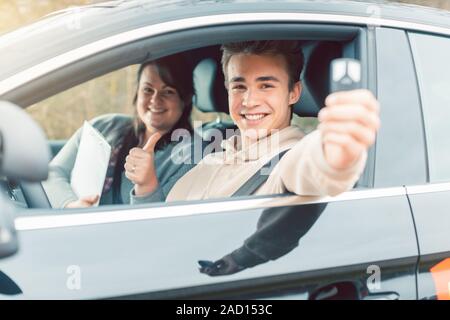 Happy student of driving school showing car keys Stock Photo