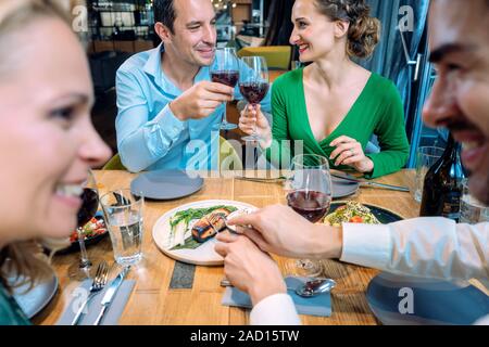 Two couples enjoying food and drink in a restaurant Stock Photo
