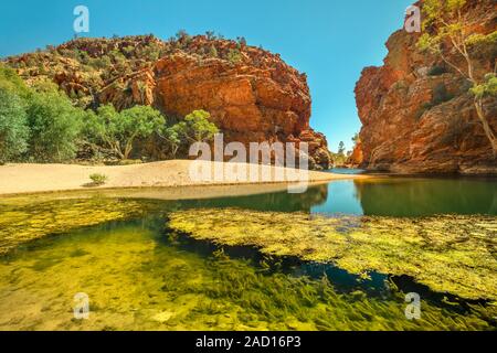 Ellery Creek Big Hole, a waterhole in a gorge surrounded by high red cliffs, is one of most popular camping, walking, swimming spots in West Stock Photo