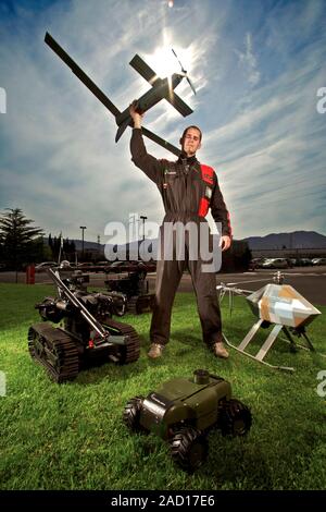 Military robots and operator. Land and air-based robots and drones being displayed by an operator. The robots are operated by remote control. These ro Stock Photo