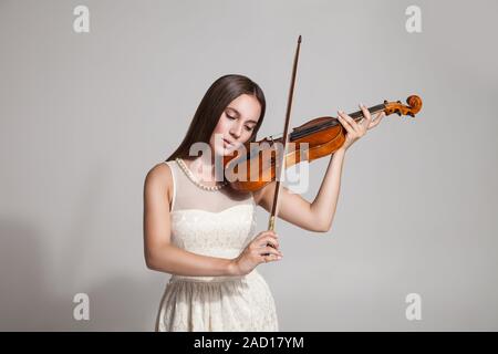 Beautiful young woman playing violin over white background Stock Photo ...