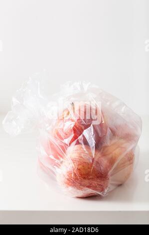 single use plastic packaging issue. apples in plastic bag Stock Photo