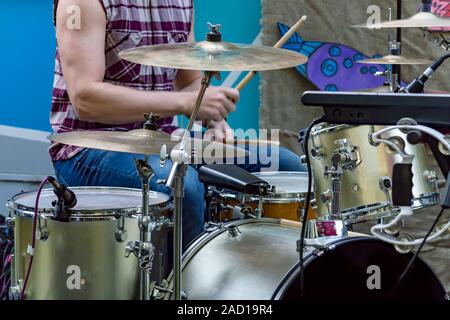 Drummer plays  drum kit in open. Side view Stock Photo