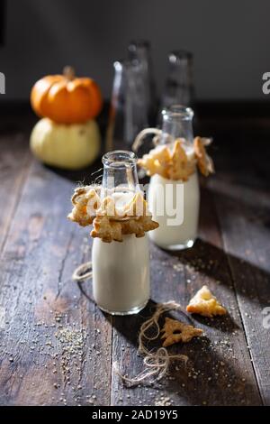 Cakes hung on milk bottles.Homemade crunchy dessert.Healthy food and drink.Wooden table Stock Photo