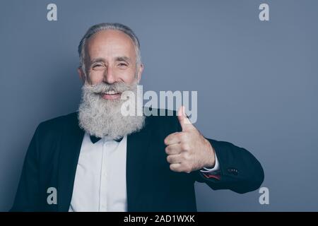 Close-up portrait of his he nice attractive chic classy trendy cheerful cheery, gray-haired man showing thumbup ad advert solution isolated over dark Stock Photo
