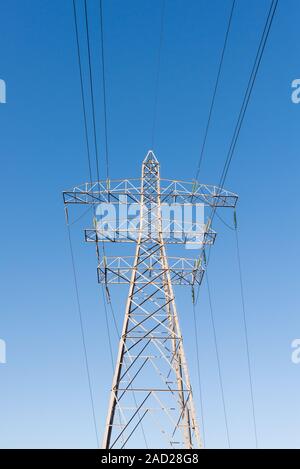 Abstract of large electricity pylon against blue sky Stock Photo