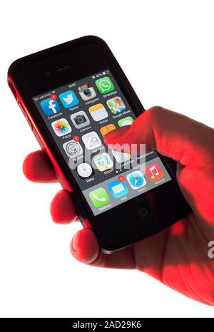 Smartphone use. Hand holding a smartphone displaying start-up icons for several mobile apps. Mobile apps are computer programs that are designed to ru Stock Photo