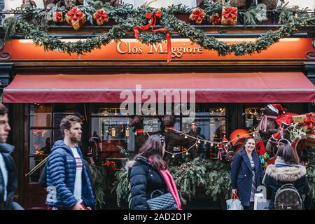 London, UK - November 24, 2019: Facade of Clos Maggiore, an award winning French restaurant in Covent Garden, London, decorated for Christmas, people Stock Photo