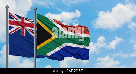 New Zealand and South Africa flag waving in the wind against white cloudy blue sky together. Diplomacy concept, international relations. Stock Photo