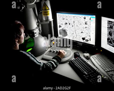 Transmission electron microscopy. Researcher operating a transmission electron microscope (TEM). In a TEM, a beam of electrons is propelled down throu Stock Photo