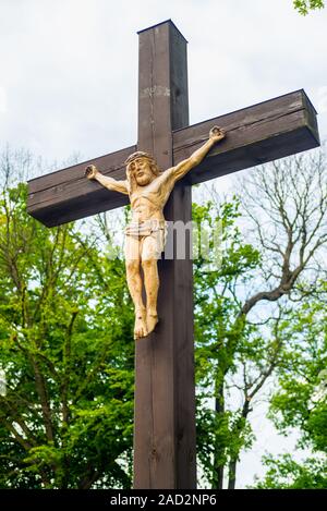 Statue of Jesus hanging on a cross with light on his face Stock Photo ...