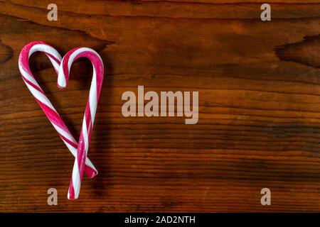 Heart shaped candy cane on wooden background Stock Photo