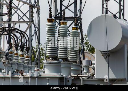 Three phase distribution transformer in an electrical substation, Current transformer, close up on the Ceramic insulators, Elements of a substation Stock Photo