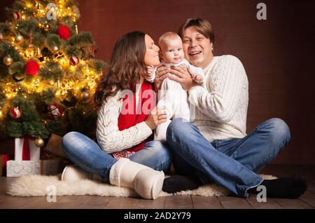 Happy family near Christmas tree at home Stock Photo