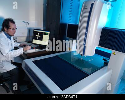 Co-ordinate measuring machine testing. Researcher testing a coordinate measurement machine (CMM), a system capable of accurate 3D measurements of comp Stock Photo