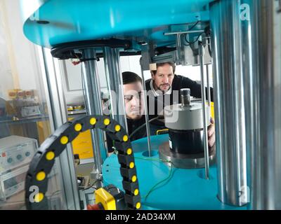 Forces measurement laboratory. Researchers working with an apparatus designed to measure standards for forces on materials and objects. International Stock Photo