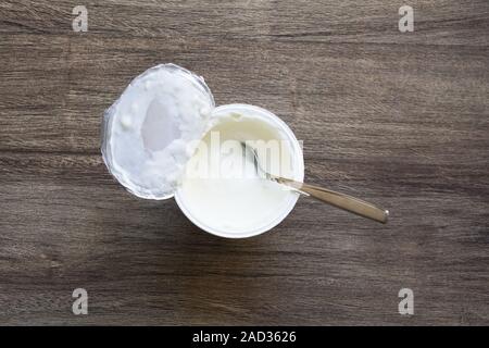 overhead view of plain or natural yoghurt in yogurt pot with dessert spoon Stock Photo