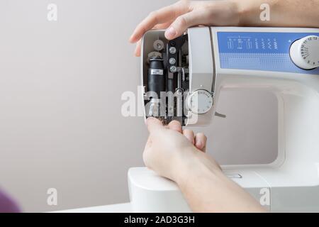 Master repairing white sewing machine Stock Photo