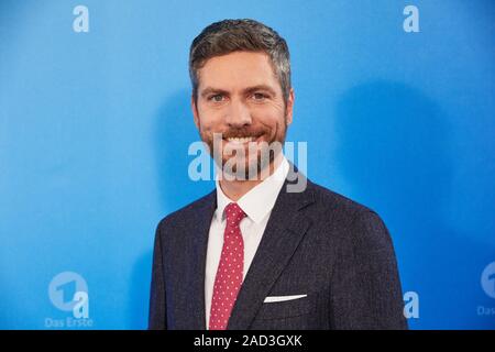 Hamburg, Germany. 03rd Dec, 2019. Ingo Zamperoni, both moderator, stands in front of a logo wall at a photo shoot on the occasion of the ARD annual press conference. Credit: Georg Wendt/dpa/Alamy Live News Stock Photo