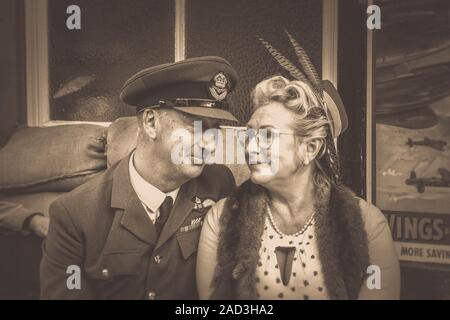 Vintage sepia close up 1940s couple in love, sitting at heritage railway station saying goodbye; Severn Valley Railway 1940s event. We'll meet again. Stock Photo
