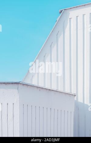Urban abstract, white concrete wall against blue sky. Geometry and shapes in architectural minimalism. Stock Photo